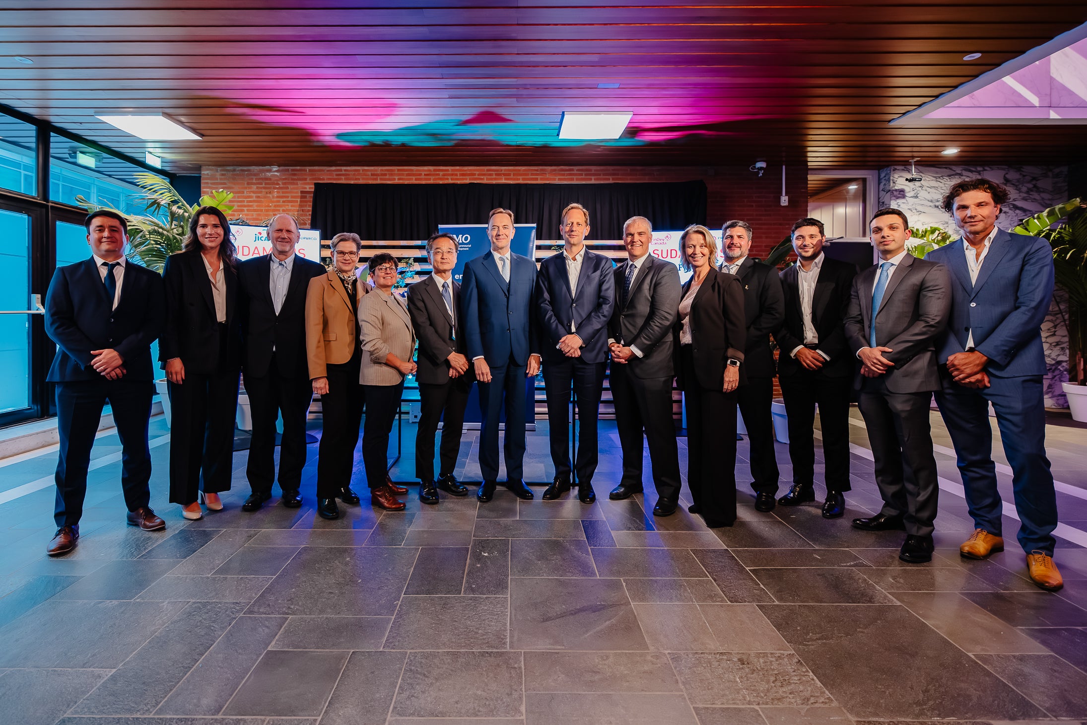 Sudameris Bank: Image of individuals from Sudameris Bank and FinDev Canada at a signing ceremony posing and looking into the camera.